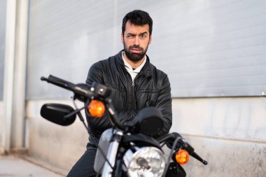 Bir motosiklet üzerinde üzgün genç adam