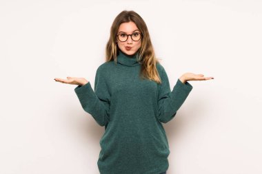 Genç kız beyaz duvar eller ve omuzlar yetiştirme süre şüpheleri üzerinde