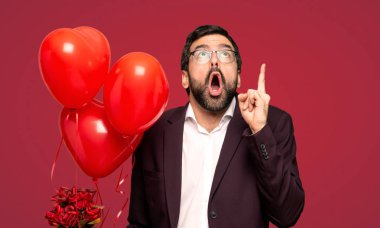 Sevgililer günü kırmızı arka plan üzerinde yukarı ve sürpriz işaret eden adam