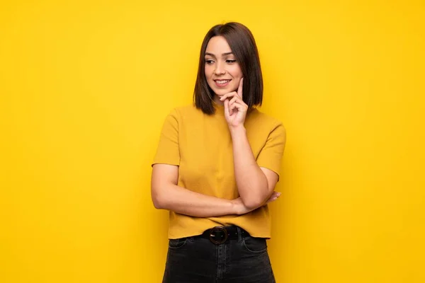 Mujer Joven Sobre Pared Amarilla Mirando Lado —  Fotos de Stock