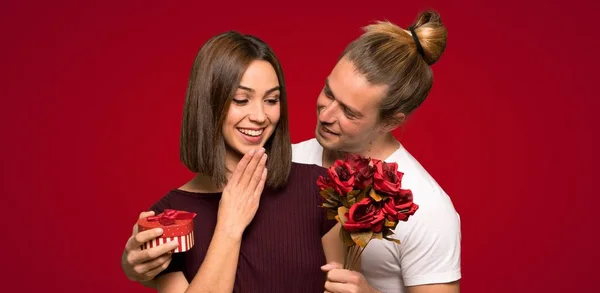 Pareja Día San Valentín Con Flores Regalos Sobre Fondo Rojo — Foto de Stock