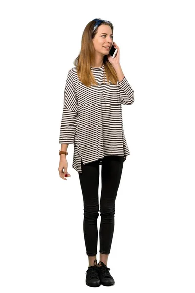 孤立した白い背景に携帯電話で会話を維持するスカーフを持つ若い女性のフルレングス ショット — ストック写真