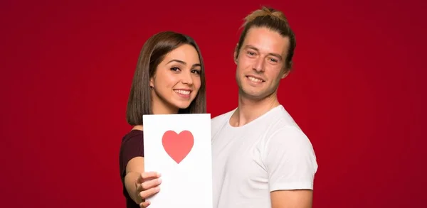 赤背景にバレンタインの日カードでバレンタインの日のカップル — ストック写真