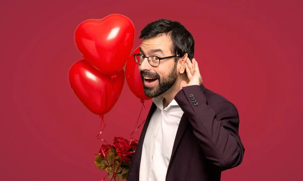 Человек День Святого Валентина Слушает Положив Руку Ухо Красном Фоне — стоковое фото