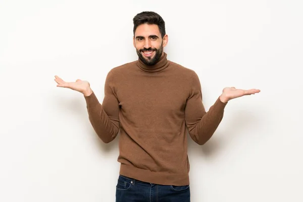 Hombre Guapo Sobre Pared Blanca Que Tiene Dudas Mientras Levanta —  Fotos de Stock