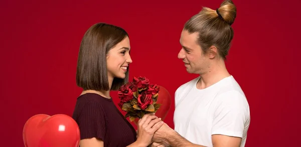 Pareja Día San Valentín Con Flores Sobre Fondo Rojo —  Fotos de Stock