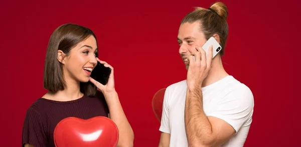 Para Walentynki Prowadzenie Rozmowy Telefonu Komórkowego Czerwonym Tle — Zdjęcie stockowe