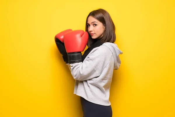 Junge Sportlerin Über Gelbem Hintergrund Mit Boxhandschuhen — Stockfoto