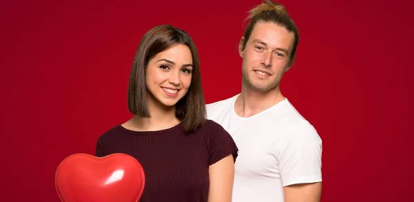 赤い背景の上幸せな表情でバレンタインにカップル — ストック写真