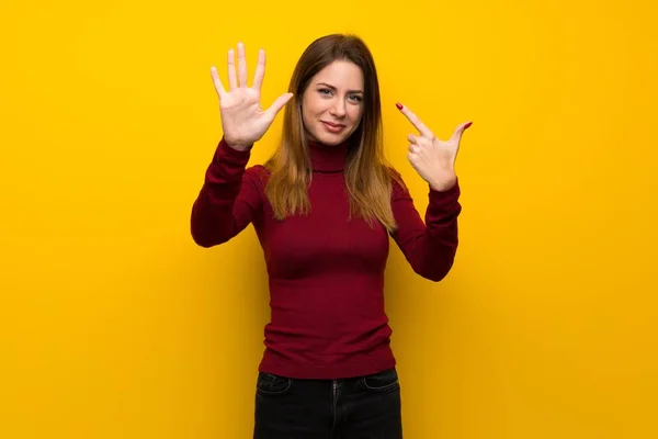 Vrouw Met Coltrui Gele Muur Tellen Zeven Met Vingers — Stockfoto