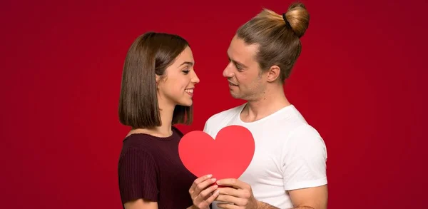 Pár Valentine Den Drží Symbol Srdce Červeném Pozadí — Stock fotografie