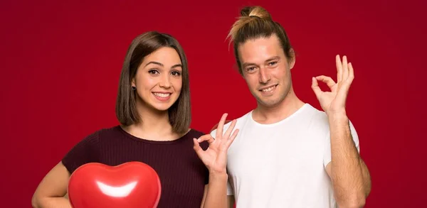 Пара День Святого Валентина Показывает Знак Пальцами Красном Фоне — стоковое фото