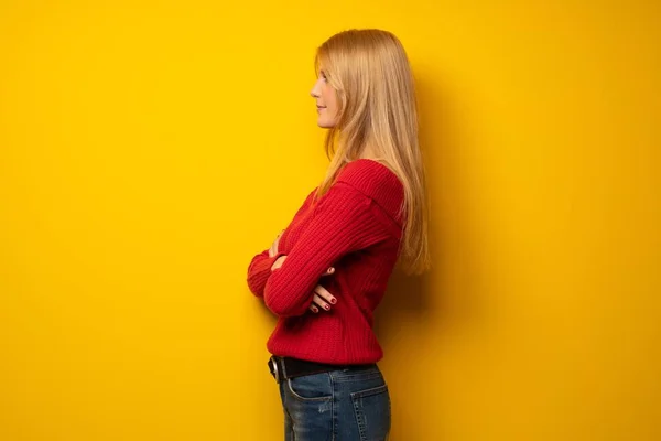 Blond Žena Přes Žlutou Zeď Boční Poloze — Stock fotografie