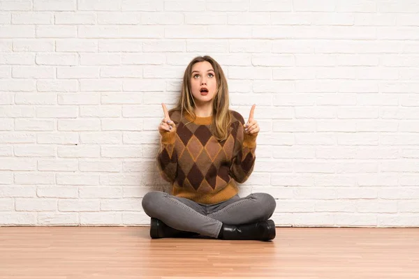 Teenager Mädchen Sitzt Überrascht Auf Dem Boden Und Zeigt Nach — Stockfoto