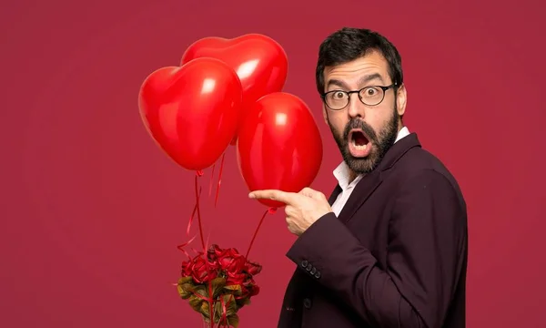Hombre Día San Valentín Sorprendido Señalando Lado Sobre Fondo Rojo —  Fotos de Stock