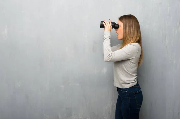 Jonge Vrouw Getextureerde Muur Kijken Verte Met Verrekijker — Stockfoto