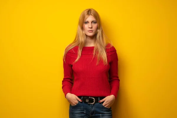 Blonde woman over yellow wall portrait