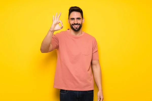 Hombre Guapo Sobre Pared Amarilla Mostrando Signo Con Los Dedos — Foto de Stock