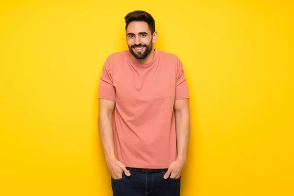 Hombre Guapo Sobre Pared Amarilla Sonriendo Mucho Mientras Pone Las — Foto de Stock