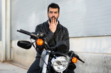 Sürpriz bir jest yapma bir motosiklet üzerinde genç adam