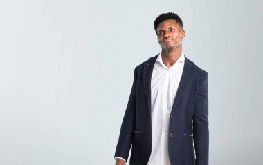 Afro-Amerikan yakışıklı olan ceket giyen şüpheler ve gri arka plan üzerinde karıştırmayın yüz ifadesi ile izole