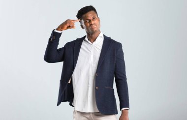 Afro-Amerikan yakışıklı izole gri arka plan baş parmak koyarak delilik jesti yapmak bir ceket