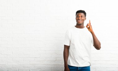 Koyu tenli adam ayakta ve parmak işaret bir fikir düşünüyorum