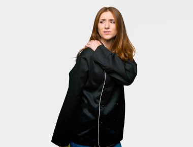 Genç redhead Şef kadın için bir çaba izole gri arka plan üzerinde yapılmış olan omuz ağrısı muzdarip