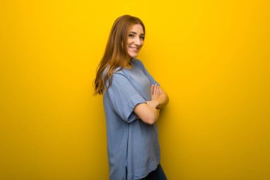 Genç Kızıl saçlı kız silah tutmak sarı duvar arka plan üzerinde yatay konumda gülümseyen süre geçti