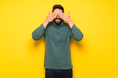 Gözleri eller tarafından kapsayan gözlüklü yakışıklı adam. İleride ne olduğunu görmek için sürpriz