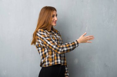 Genç Kızıl saçlı kız iyi bir anlaşma sonra grunge duvar el sıkışma yüzünden