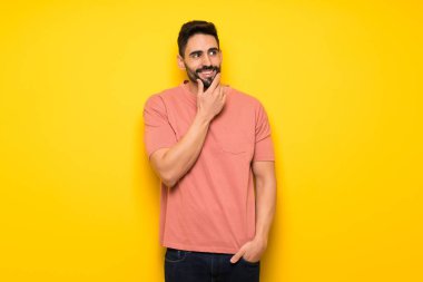 Sarı duvar ararken bir fikir düşünce yakışıklı adam