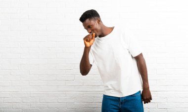 Koyu tenli adam öksürük ile acı ve kötü hissediyor