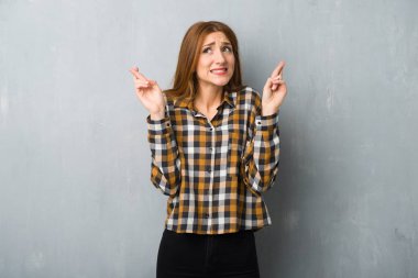 Grunge Duvar ile en iyi dilek ve geçiş parmakları genç Kızıl saçlı kız