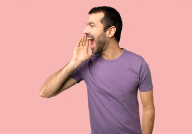 Lateral izole pembe arka plan üzerine açık geniş ağızlı bağırmayı yakışıklı adam