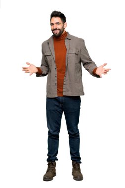 İzole beyaz arka plan üzerinde gülümseyen sakallı yakışıklı adam tam uzunlukta atış