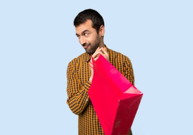 Alışveriş torbaları izole mavi zemin üzerine bir şey entrikacı olan adam