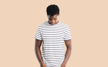 Koyu tenli adam ayakta ve izole koyu sarı arka plan üzerinde seyir çizgili gömlek ile