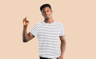 Koyu tenli adam ile gösterilen ve işareti en iyi izole koyu sarı zemin üzerine bir parmak kaldırma çizgili gömlek