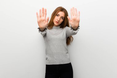 Kızıl saçlı kız dur jest yapmak için beyaz duvar üzerinde bir görüş ile hayal kırıklığına