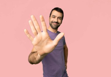 Yakışıklı adam beş ile izole pembe bir arka plan üzerinde parmak sayma