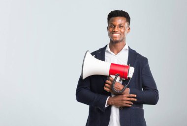Afro-Amerikan yakışıklı bir megafon izole gri arka plan üzerinde tutan bir ceket