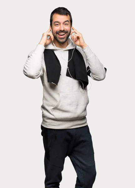 Hombre Deportivo Con Auriculares Sobre Fondo Gris Aislado —  Fotos de Stock