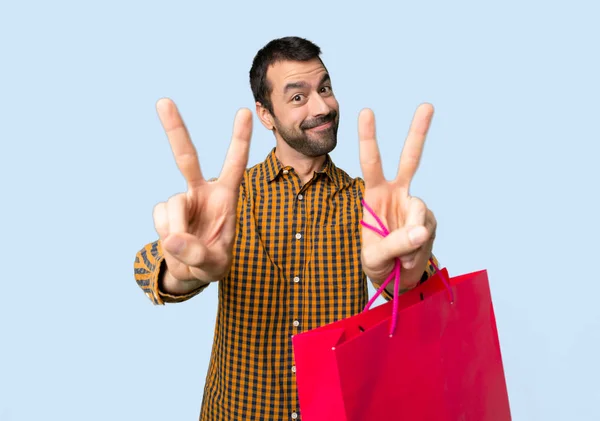Mannen Med Shoppingkassar Leende Och Visar Seger Tecken Med Båda — Stockfoto