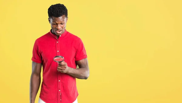 Молодий Афроамериканець Людиною Проведення Збільшувальним Склом Жовтому Фоні — стокове фото