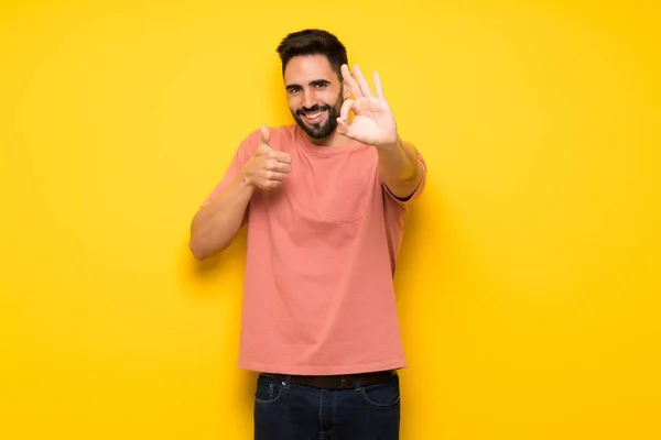 Hombre Guapo Sobre Pared Amarilla Mostrando Signo Con Dando Gesto — Foto de Stock
