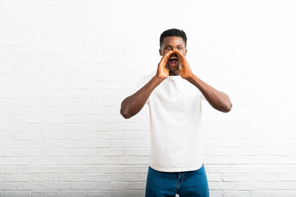 Dark skinned man shouting with mouth wide open and announcing something