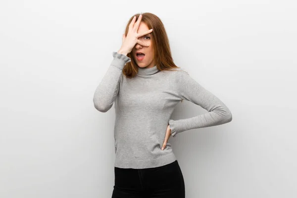 Rothaarige Mädchen Über Weiße Wand Mit Überraschung Und Schockiertem Gesichtsausdruck — Stockfoto