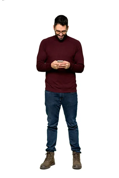 分離の白い背景の上 携帯電話でメッセージを送信する眼鏡のハンサムな男のフルレングスのショット — ストック写真