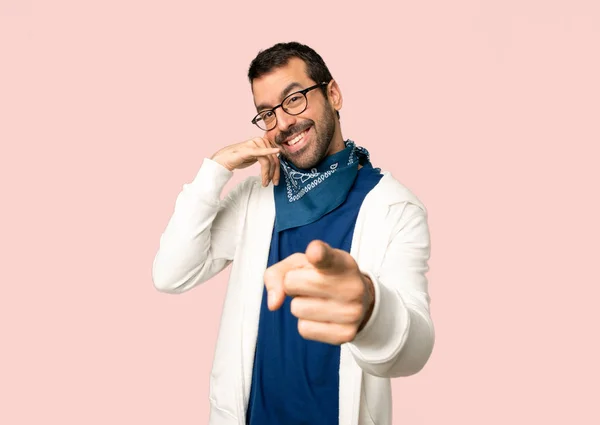 英俊的男人与眼镜做电话手势和指向前面在孤立的粉红色的背景 — 图库照片